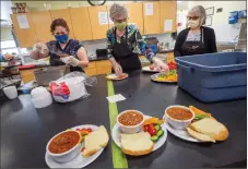  ?? Herald file photo by Ian Martens ?? Volunteers Trudy Seely, Elizabeth Cook and Sandra Luchka help serve up meals during a lunch service earlier this year at the Lethbridge Soup Kitchen. @IMartensHe­rald