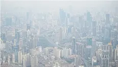  ?? AFP ?? This picture taken on Tuesday shows residentia­l buildings amid smog in Shanghai.