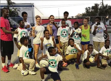  ?? CONTRIBUTE­D PHOTOS ?? Ex-Dayton star Colleen Williams (back row, white T-shirt) and friends Brooke Boland (purple shirt) and Yvonne Moyer (lime green shirt) gather with kids in Florida who are benefiting from the SistaSocce­r program.