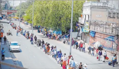  ?? Manish Swarup The Associated Press ?? People line up to board trains Tuesday outside a New Delhi railway station. India is reopening parts of its colossal rail network as the country looks at easing its nearly seven-week strict lockdown amid an increase in coronaviru­s infections.