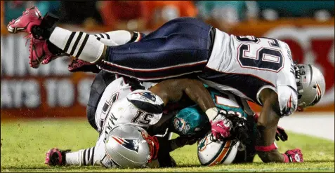  ?? BILL INGRAM /THE PALM BEACH POST 2010 ?? Dolphins wide receiver Davone Bess (bottom right) is crushed by Patriots defenders during a 2010 game in Miami. Bess has CTE, his lawyer says, and has engaged in episodes of bizarre behavior.