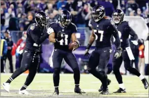  ?? GETTY IMAGES/AFP ROB CARR/ ?? Anthony Levine (left) and CJ Mosley of the Baltimore Ravens celebrate an intercepti­on in the fourth quarter against the Houston Texans on Monday in Baltimore, Maryland.