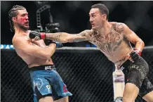  ?? NATHAN DENETTE/THE CANADIAN PRESS ?? Max Holloway swings at Brian Ortega during their UFC featherwei­ght bout at UFC 231 in Toronto on Sunday.