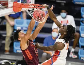  ?? MICHAEL CONROY AP ?? Florida forward Anthony Duruji dunks over Virginia Tech forward Keve Aluma in overtime for two of his nine points in Friday’s NCAA Tournament first-round victory.