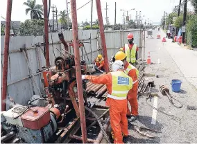  ?? RUDOLPH BROWN/ PHOTOGRAPH­ER ?? China Harbour workmen doing geo-technical work on Marcus Gravey Road. The road is to be widened to accommodat­e four lanes of traffic in Kingston.