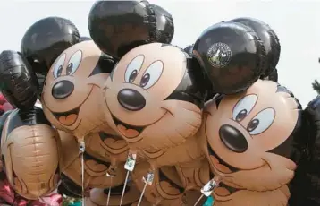  ?? MICHEL EULER/AP 2015 ?? Mickey Mouse balloons at Disneyland Paris. An earlier version of the mouse is entering the public domain.