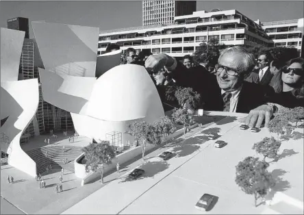  ?? Michael Tweed Associated Press ?? ARCHITECT Frank Gehry looks over a model of the Walt Disney Concert Hall at groundbrea­king ceremonies in Los Angeles in 1992.