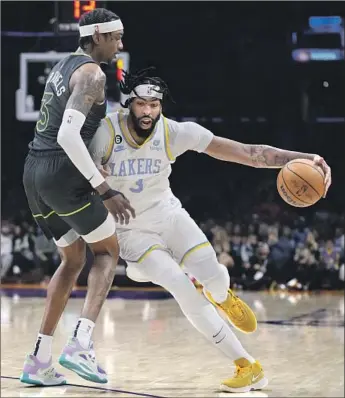  ?? MARCIO JOSE SANCHEZ Associated Press ?? THE LAKERS’ ANTHONY DAVIS drives against the Timberwolv­es’ Jaden McDaniels during the first half. Davis returned to the lineup after sitting out Wednesday as a precaution for his right foot injury.