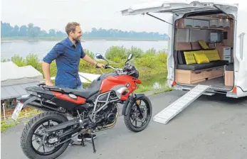  ?? FOTO: DPA ?? Große Klappe: In diesem Reisemobil parkt das Motorrad während der Fahrt direkt im Wohnzimmer.