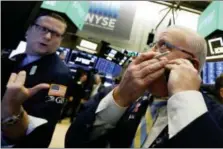  ?? RICHARD DREW — THE ASSOCIATED PRESS FILE ?? Trader Thomas Ferrigno, right, and specialist Gregg Maloney work on the floor of the New York Stock Exchange.