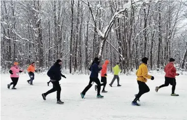  ?? Don Campbell / The Herald-Palladium via AP ?? Runners sprint down Forest Park Avenue on Saturday in Watervliet, Mich.,in the 5th annual FROSTY 5K Run/Walk. Meanwhile along the East Coast, finding a plumber for frozen pipes was a challenge.