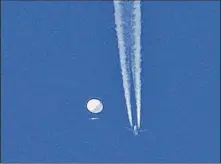  ?? Brian Branch / Associated Press ?? A balloon drifts above Kingstown, N.C., with a jet and its contrail seen below it. The U.S. says the Chinese spy balloon was moving at an altitude of about 60,000 feet.