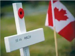 ?? CP PHOTO DARRYL DYCK ?? A Canadian flag and a poppy on a wooden cross are seen at the grave of veteran, Sgt. W.G. Hamilton, of the 47th Battalion of the Canadian Expedition­ary Force, in the military section of Fraser Cemetery, in New Westminste­r, B.C., on Tuesday.