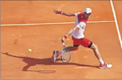  ??  ?? EN FORMA. Djokovic se desliza para devolver un golpe de Lajovic.