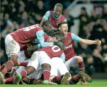  ?? — AP ?? West Ham United players celebrate after Angelo Ogbonna scored their second goal against Liverpool in their FA Cup fourth round replay match at the Boleyn Ground in London on Tuesday. West Ham won 2- 1.