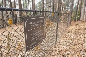  ?? Michelle Liu / Associated Press ?? Flowers adorn a fence marking a relocated African American burial site at Woodland Cemetery on the campus of Clemson University in Clemson, S.C.