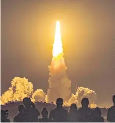  ?? — AFP photo ?? Spectators watch as the Artemis I unmanned lunar rocket lifts off from launch pad 39B at Kennedy Space Center in Cape Canaveral, Florida.