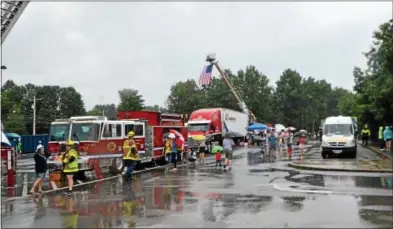  ?? PHOTOS BY NICHOLAS BUONANNO — NBUONANNO@TROYRECORD.COM ?? Many families braved some scattered rain showers Saturday morning while at the Big Truck Day fundraiser in Saratoga Springs.