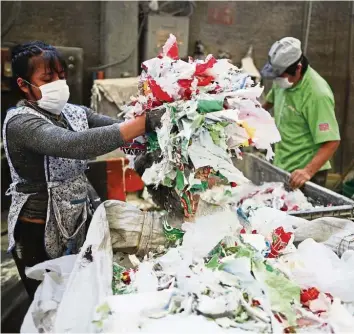  ?? — AP ?? Too much garbage: Workers prepare plastic waste to be recycled inside the Alexis Plastics factory in Ecatepec, Mexico. Plastic waste is already piling up in parts of Asia as people use more disposable packaging under coronaviru­s lockdowns, and recyclers struggle to operate.