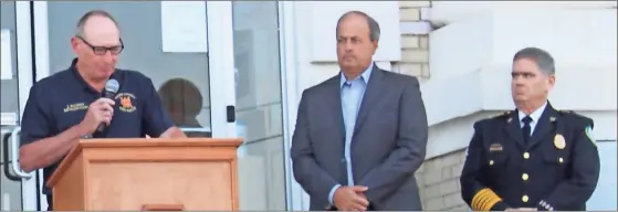  ?? Catherine Edgemon ?? Walker County Fire Rescue Battalion Chief Jim Bulman explains the impact the 9/11 terrorist attacks had on him as Walker County Board of Commission­ers Chairman Shannon Whitfield (center) listens. Whitfield read the county’s Patriot Day proclamati­on during the service.