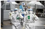  ?? LEE YONG-HWAN/NEWSIS VIA AP ?? Medical staff members arrive for a duty shift Friday at Dongsan Hospital in Daegu, South Korea. The new coronaviru­s causes mild or moderate symptoms for most people.