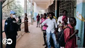  ??  ?? Colas a la entrada de un centro electoral en la capital Bangui vigilado por agentes de la MINUSCA, la misión de estabiliza­ción desplegada en el país por Naciones Unidas.