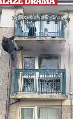  ??  ?? brave stranger A man comforts the terrified residents on their balcony as smoke billows from the middle flat