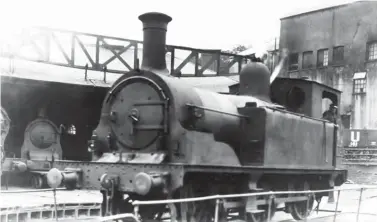  ?? Great Western Trust Collection ?? An undated view of the turntable in use at Treherbert’s semi-roundhouse records one of the trio of Kitson & Co-built ‘H’ class 0-6-0Ts completed in 1884 for use on Pwllyrebog incline, Treherbert being its home shed. Originally Taff Vale Railway Nos 141-143 and then GWR Nos 792-794, their railway was just 1¾ miles long, but 1 in 13 at worst and 1 in 30 at best. The steepest part of the climb was cable assisted, with the locomotive at the downhill end of trains, empties to Clydach Vale Colliery (or a light engine) counter-balancing downhill trains of loaded coal. To the left, within the shed the fitting staff have a handy trolley in use ahead of a Hurry Riches 0-6-2T that is yet to be re-boilered by the GWR, although that process proved fairly lengthy, running in various forms but beginning in earnest in 1924 and continuing well beyond the demolition of Treherbert semi-roundhouse in 1931. Surprising­ly, given limited room, a singleline ran between the semi-roundhouse and the large brewery structure that provides a backdrop, this line acting as a loop serving Lady Margaret Colliery.