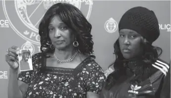  ?? VINCE TALOTTA/TORONTO STAR ?? Anthony Spencer’s mother Beverley holds up a photo of the murdered aspiring rapper while his sister Susan looks on at a news conference Tuesday at Toronto police headquarte­rs. Spencer was fatally shot in January.