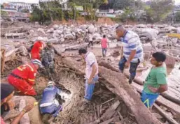  ??  ?? Rescuers looking for people among the rubble left by mudslides following heavy rains in Mocoa, Putumayo department, southern Colombia on Saturday.