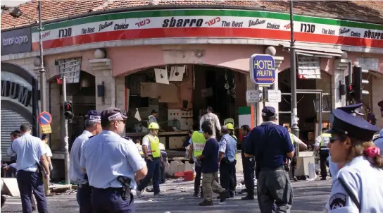  ?? (Reuters) ?? A GAPING hole is left in the shop front of the Sbarro pizzeria after a suicide bombing that killed at least 18 people and wounded more than 80 others in Jerusalem August 2001.