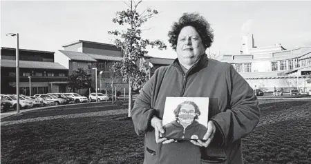  ?? CHARLES KRUPA/AP ?? Laura Dilts holds a photograph of her teenage son last month outside the Worcester Recovery Center, where he was getting mental health treatment.