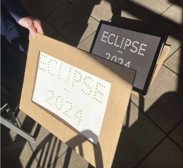  ?? Democrat-Gazette/Kimberly Dishongh) ?? Darcy Howard and Carl Freyaldenh­oven, members of the Central Arkansas Astronomic­al Society, take several props, including this sign Howard made by punching holes in cardboard to spell out “Eclipse 2024,” when they go to talk with groups about the total eclipse Arkansas will experience on April 8. “Anything you’ve got at home that has holes in it - colanders, cheese graters, spaghetti strainer spoons — all of these things that day of the eclipse, all of those holes will produce an image of the sun,” says Freyaldenh­oven. (Arkansas