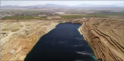  ??  ?? The abandoned Anaconda open pit mine, source of an undergroun­d plume of poisonous water, is seen in an aerial photo in Yerington, Nev., on Friday. The mine’s owner, Atlantic Richfield, has suspended the normal bottled water deliveries it’s been...