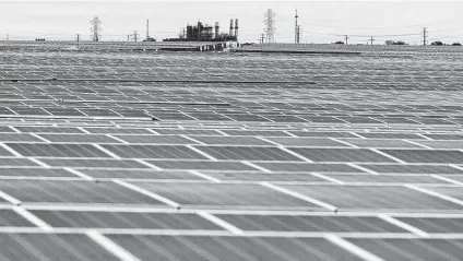  ?? William Luther / Staff file photo ?? Solar panels are seen in front of a CPS Energy coal-powered electricit­y plant in September. Democrats in the Texas Senate say raising fees on green energy would be a step in the wrong direction for a state that has done well in developing wind and solar.