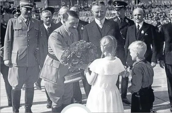  ?? ULLSTEIN BILD / GETTY ?? Flores y niños. Hitler recibe un ramo de manos
infantiles al poner en 1934 la primera piedra del Reichsbank en Berlín
