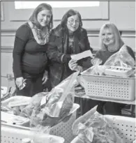  ?? Submitted photo ?? PREPARING ORDERS: Market managers Hannah Seewald, left, Karen Holcomb and Nan Cameron get orders ready for co- op customers during a recent pick- up day at Emergent Arts in the Dryden Pottery Building.