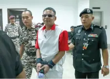  ?? – Bernama photo ?? The accused is led to the court for the hearing.