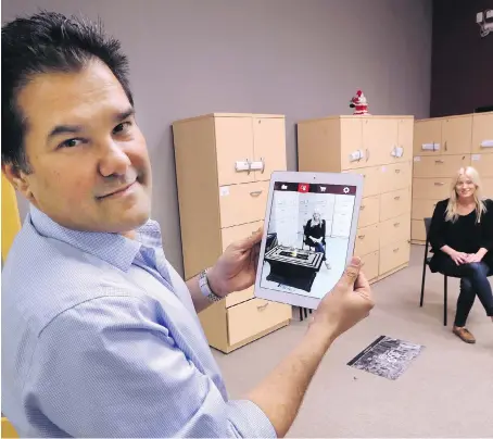  ?? DAN JANISSE ?? Edwin Padilla, president of Powerball Technologi­es, demonstrat­es his app on Tuesday at the Downtown Windsor Business Accelerato­r with Danielle Gifford, director of sales and marketing. The app allows the user to virtually view products in their space.