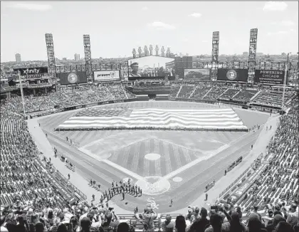  ?? MARK BLACK/AP ?? An American flag is unfurled in the outfield before the start of a game between the White Sox and Tigers on July 4, 2019, in Chicago. MLB owners gave the go-ahead Monday for a proposal to the players’ union that could lead to the season starting around this year’s holiday.