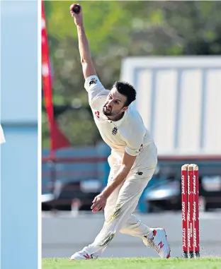  ??  ?? Fighting fire with fire: Mark Wood is mobbed by team-mates after stepping up his pace to rip through the West Indies batting. Moeen Ali (left), celebratin­g dismissing John Campbell, weighed in with four wickets