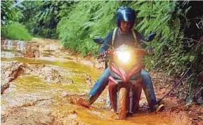  ?? PIC BY NAZIRUL ROSELAN ?? The picture of Ahmad Saidin Mohd Idris riding through a muddy road to reach SK Lenjang in Kuala Lipis has earned him instant fame.