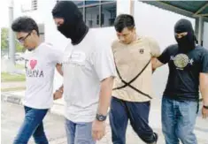 ??  ?? ... Online traders Muhammad Hassan Syaudi Omar (left) , 23, and Mohd Shaiful Mohd Jaafar, 31, at the Sungai Petani magistrate's court yesterday to face charges of providing services for terrorist activities. No plea was recorded. Magistrate Adibah...