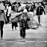  ?? REN QI / CHINA DAILY ?? A Chinese woman carrying goods is about to cross the ChinaVietn­am border.