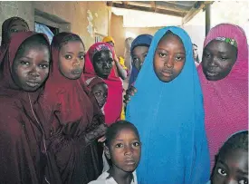  ?? [JOSSY OLA/AP PHOTO] ?? Aishat Alhaji, second right, one of the kidnapped girls from the Government Girls Science and Technical College Dapchi who was freed, is photograph­ed Wednesday after her release, in Dapchi, Nigeria.