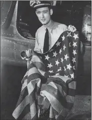  ??  ?? Lt. John K. Bremyer holds the Perry flag, which caused him to miss a date with his steady girl but allowed him to share a date with history. (Formal Surrender of the Japanese Empire on the Battleship Missouri, featuring the Perry flag)