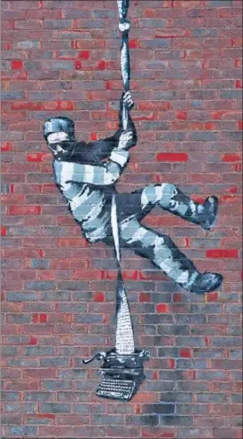  ?? REUTERS ?? A giant graffiti, possibly created by elusive artist Banksy, has appeared on the side of Reading Prison in the UK. The mural shows a prisoner resembling the facility’s famous inmate Oscar Wilde escaping on a rope made of bedsheets tied to a typewriter.