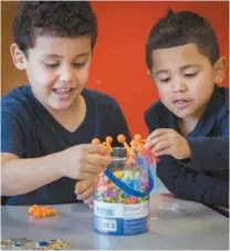  ?? PHOTOS JACQUES NADEAU LE DEVOIR ?? À gauche : Yara et « les amis » du CPE apprennent à compter en sautant par dessus un dé, sous la supervisio­n de l’éducatrice Karla. À droite : à la maternelle 4 ans, on apprend beaucoup par le jeu, comme en témoignent ces deux enfants de la classe de Madame Céline, à l’école Saint-Noël Chabanel.