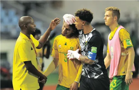  ?? THABANG LEPULE Backpagepi­x ?? SOUTH Africa captain Ronwen Williams consoles teammate Rushine de Reuck after losing to Ghana through a controvers­ial penalty. |