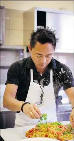  ??  ?? Chef Nathan Fong’s recent trip to Italy yielded a wealth of comfort- food inspiratio­n. Here, he prepares a dish in Parma, in Academia Barilla’s kitchen.